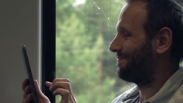 Красивий чоловік працює з планшетом на поїзді — стокове відео