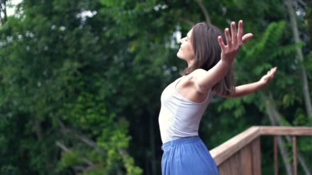 Woman with wide open arms enjoying day on terrace — Stock Video