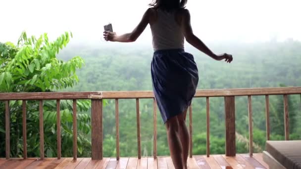 Mujer escuchando música y bailando en la terraza — Vídeos de Stock