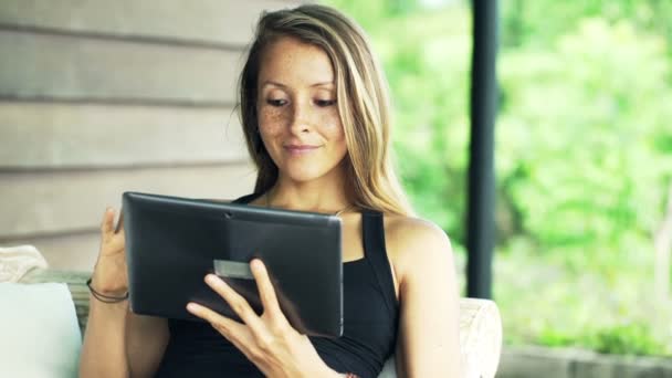 Mujer usando tableta en el sofá — Vídeos de Stock