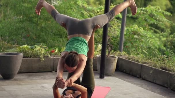 Flickvänner utöva acro yoga på terrassen — Stockvideo
