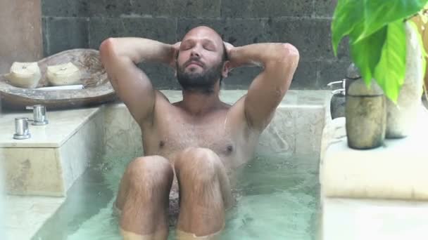 Jovem relaxante na banheira no banheiro — Vídeo de Stock