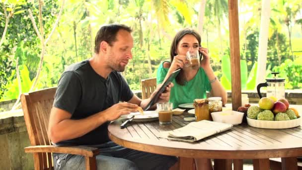 Casal com computador tablet, falando no celular no terraço — Vídeo de Stock