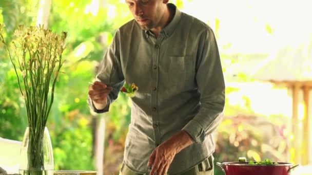 Человек смешивания салат на кухне — стоковое видео