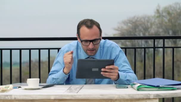 Businessman reading news from stock market on his tablet — Stock Video