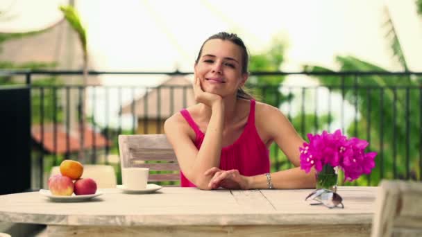 Женщина пьет кофе у стола на террасе — стоковое видео