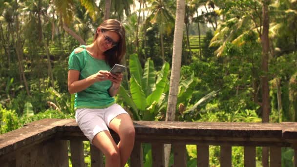 Γυναίκα γραπτών μηνυμάτων στο smartphone στη βεράντα — Αρχείο Βίντεο