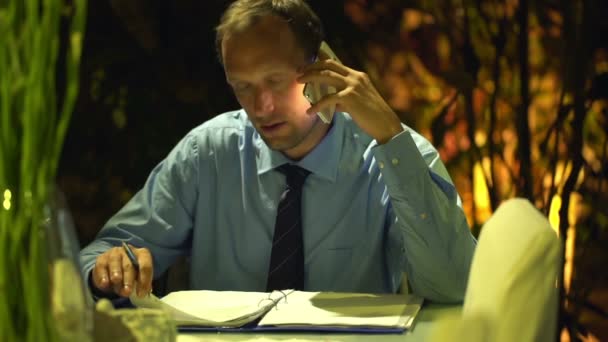 Businessman talking on cellphone with documents — Stock Video