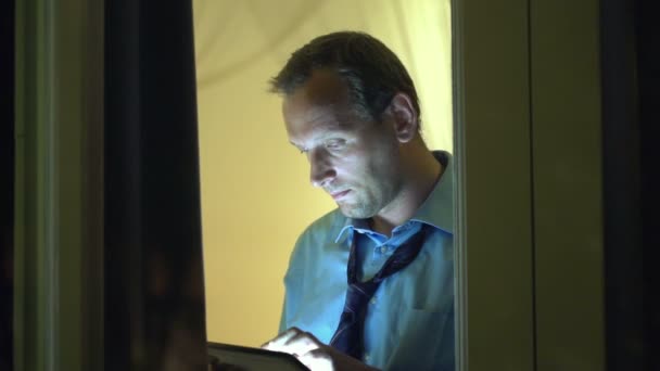 Man standing with tablet computer by window — Stock Video