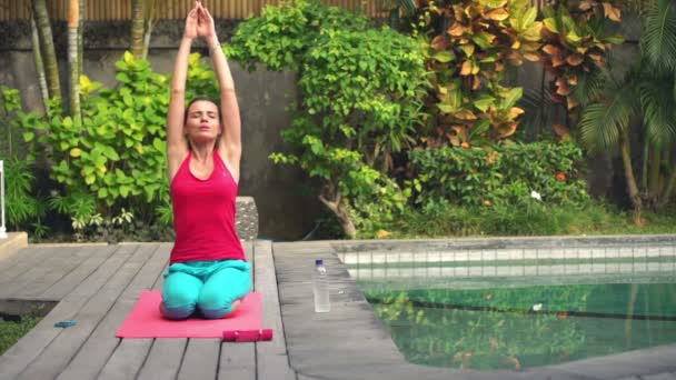 Woman doing yoga pose on mat in garden — Stock Video