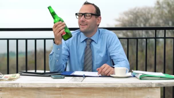 Glücklicher Geschäftsmann trinkt Bier auf der Terrasse — Stockvideo