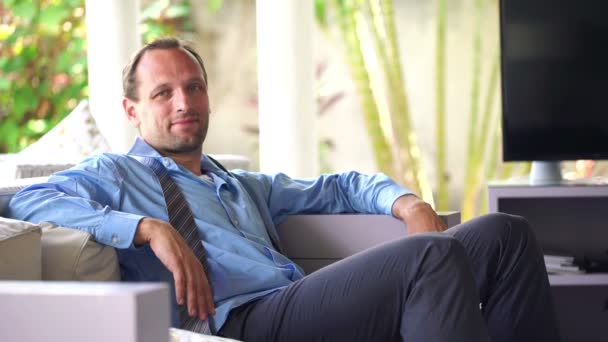 Relajado hombre de negocios sentado en el sofá en casa — Vídeos de Stock