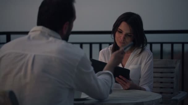 Paar mit Tablet und Handy am Tisch — Stockvideo