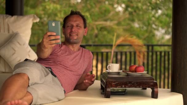 Мужчина делает селфи фото с мобильного телефона — стоковое видео