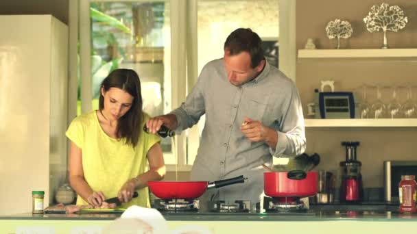 Couple slicing meat and pouring olive oil on pan — Stock Video