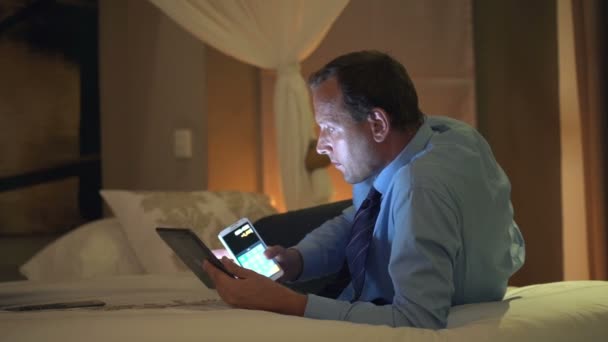 Geschäftsmann mit Tablet-Rechendaten auf Smartphone — Stockvideo