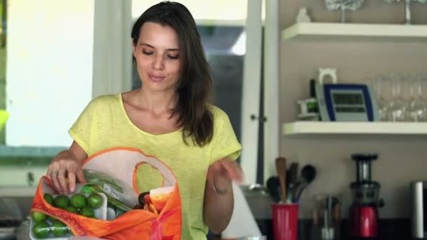 Mujer desempacar comestibles en la cocina en casa — Vídeos de Stock