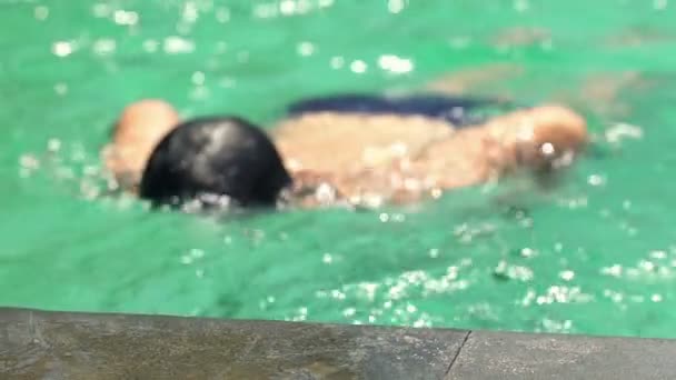 Мальчик плавает в бассейне — стоковое видео