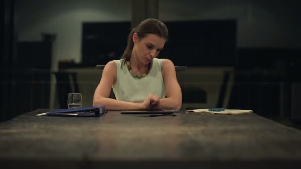Скучная деловая женщина пьет и сидит за столом — стоковое видео