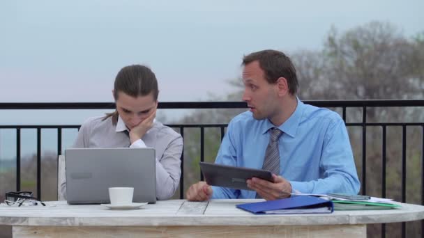 Jefe con tableta gritando a la mujer de negocios en la terraza — Vídeo de stock