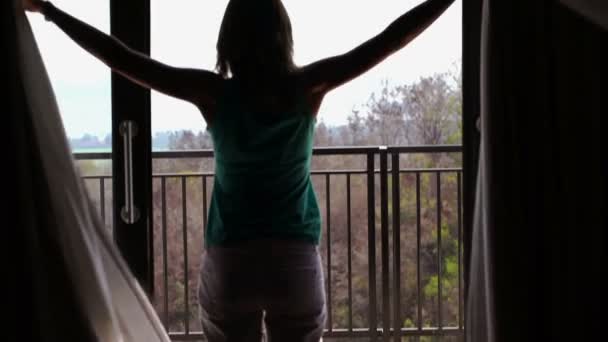 Vrouw onthullen gordijnen en stretching — Stockvideo