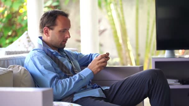 Zakenman texting op smartphone thuis — Stockvideo