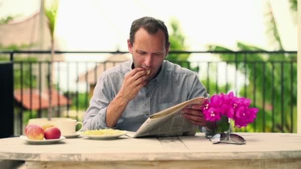 Hombre leyendo el periódico durante el descanso del café — Vídeo de stock
