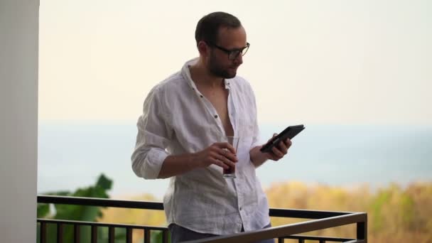 Man verzenden sms op smartphone op terras — Stockvideo