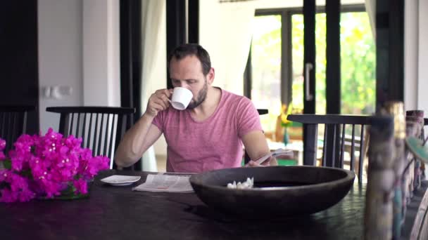 Man reading newspaper and drinking coffee — Stock Video
