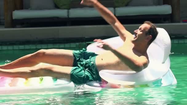 Filho jogando seu pai de colchão de ar na piscina — Vídeo de Stock