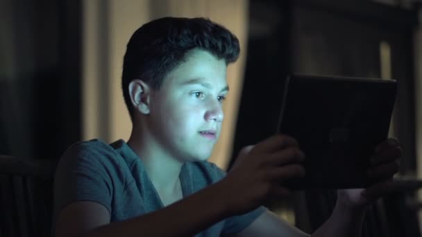 Adolescente jugando juego en la computadora tableta — Vídeo de stock