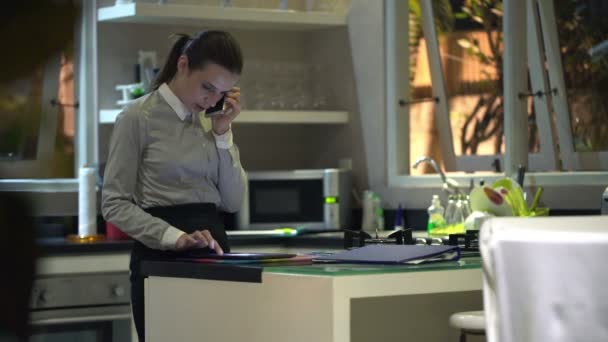 Mujer de negocios con teléfono celular y tableta en la cocina — Vídeos de Stock