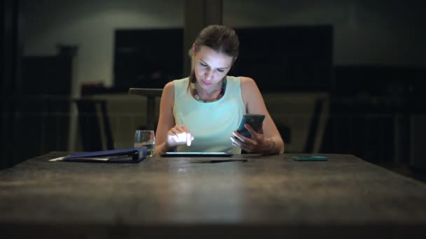 Бізнес-леді порівняння даних на смартфоні і планшеті — стокове відео