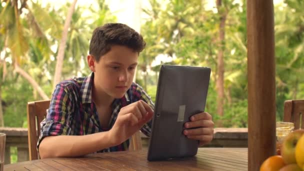 Tiener met behulp van tablet pc op terras — Stockvideo