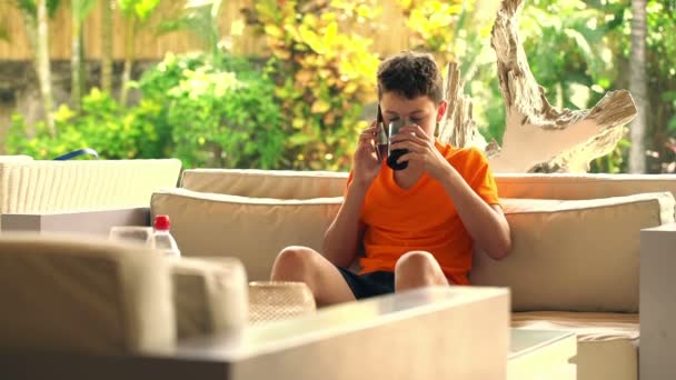 Tinédzser beszél a mobilját, és iszik szódával — Stock videók