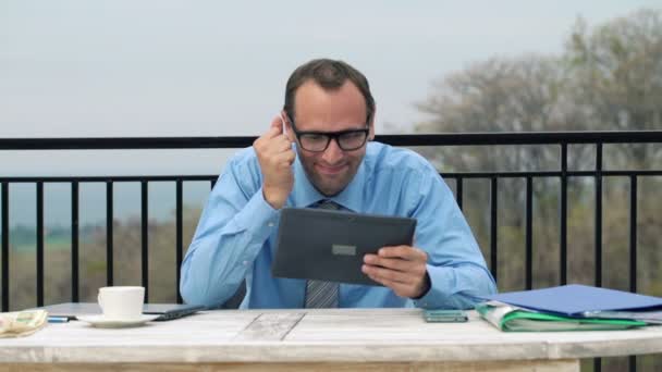 Бізнесмен читає новини з фондового ринку на своєму планшеті — стокове відео