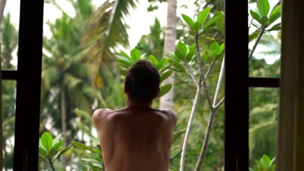 Man walking out and stretching on terrace — Stock Video