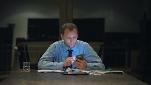 Empresario enviando sms en smartphone en la oficina — Vídeos de Stock