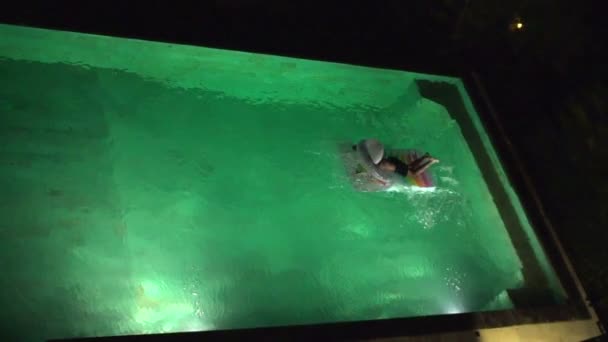 Garçon sautant sur matelas flottant dans la piscine — Video