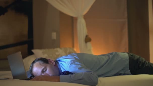 Hombre de negocios durmiendo con portátil en la cama — Vídeos de Stock