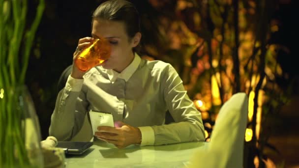 Geschäftsfrau mit Smartphone trinkt zu Hause Wasser — Stockvideo