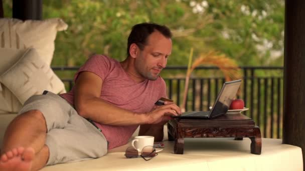 Человек делает онлайн-покупки на ноутбуке — стоковое видео