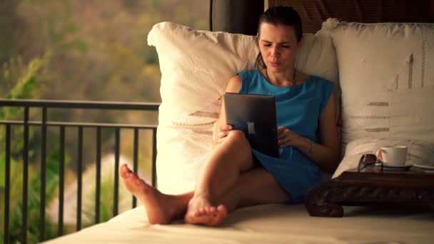 Vrouw met de tablet pc op gazebo bed — Stockvideo