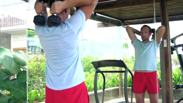 Man exercising with dumbbells in gym — Stock Video