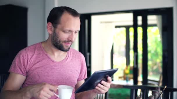 Man met tablet pc drinken koffie — Stockvideo