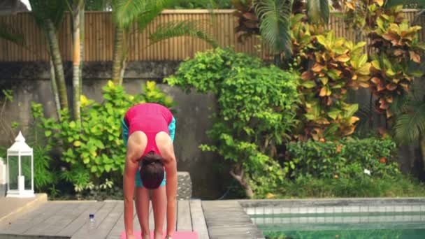 Žena, která dělá ohyb cvičení na podložce v zahradě — Stock video