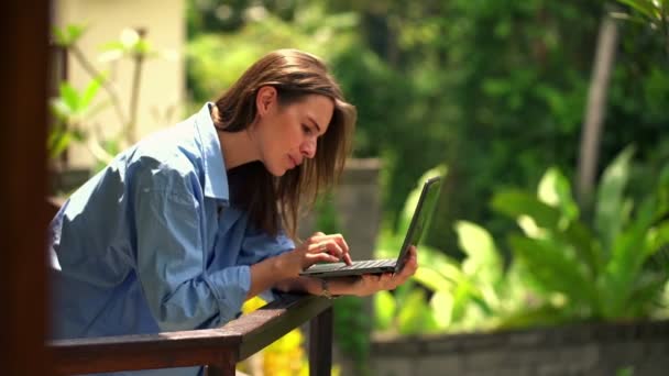 Mooie vrouw met laptop op terras — Stockvideo