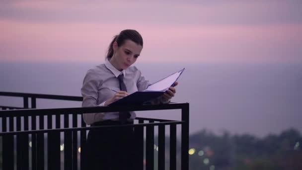 Podnikatelka, psaní poznámek v dokumentech na terase — Stock video