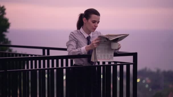 Бізнес-леді читає газету, п'є каву на терасі — стокове відео