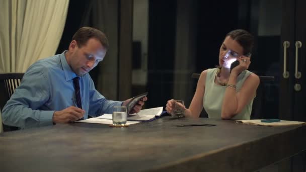 Pareja de negocios hablando por teléfono celular, usando tableta y escritura — Vídeo de stock